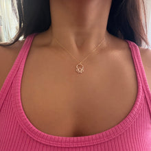 Necklace with a gold pendant worn by a person is a 16” length.